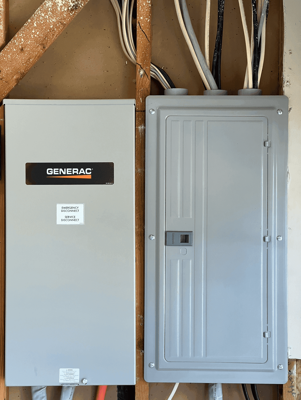 Generac whole-home standby generator transfer switch wired beside a residential breaker panel — installed by M Electric in a Tulsa home